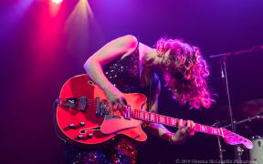 Julia Deans playing guitar on stage