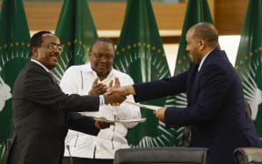 Redwan Hussein (L), Representative of the Ethiopian government, and Getachew Reda (R), Representative of the Tigray People's Liberation Front (TPLF), shake hands a peace agreement between the two parties during a press conference regarding the African Union-led negotiations to resolve conflict in Ethiopia at the Department of International Relations and Cooperation (DIRCO) offices in Pretoria on November 2, 2022. (Photo by PHILL MAGAKOE / AFP)