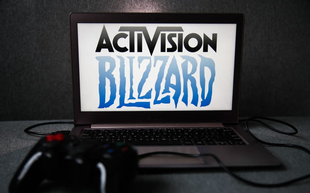 Activision Blizzard logo displayed on a laptop screen and a gamepad are seen in this illustration photo.