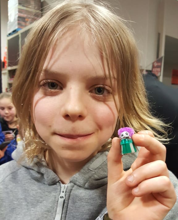 An enthusiastic young roboticist with a newly minted Bristlebot.