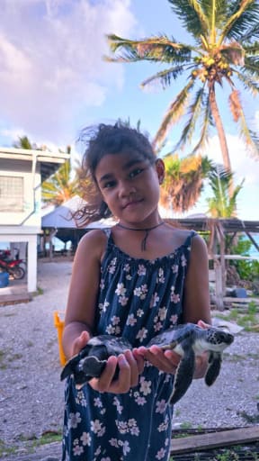 Ilissapesi Sakalia holding her turtles "Popo" and "Uto" - two of the more than 30 sea turtles found in Tokelau in 2025.