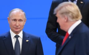Russian President Vladimir Putin, left, looks at US President Donald Trump before posing for a family photo before the G20 summit in Argentina, 30 November, 2018.