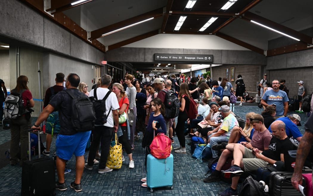Passengers try to rest and sleep after canceled and delayed flights while others wait to board flights off the island as thousands of passengers were stranded at the Kahului Airport (OGG) in the aftermath of wildfires in western Maui in Kahului, Hawaii on August 9, 2023. The death toll from a wildfire that turned a historic Hawaiian town to ashes has risen to 36 people, officials said on August 9.