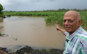 Sugar cane grower Chandrika Prasad surveys flooded cane in Tavua