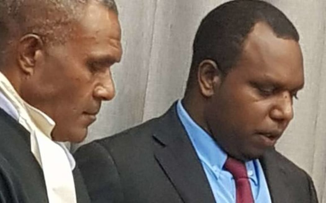Andrew Napuat (right) being sworn into Parliament.