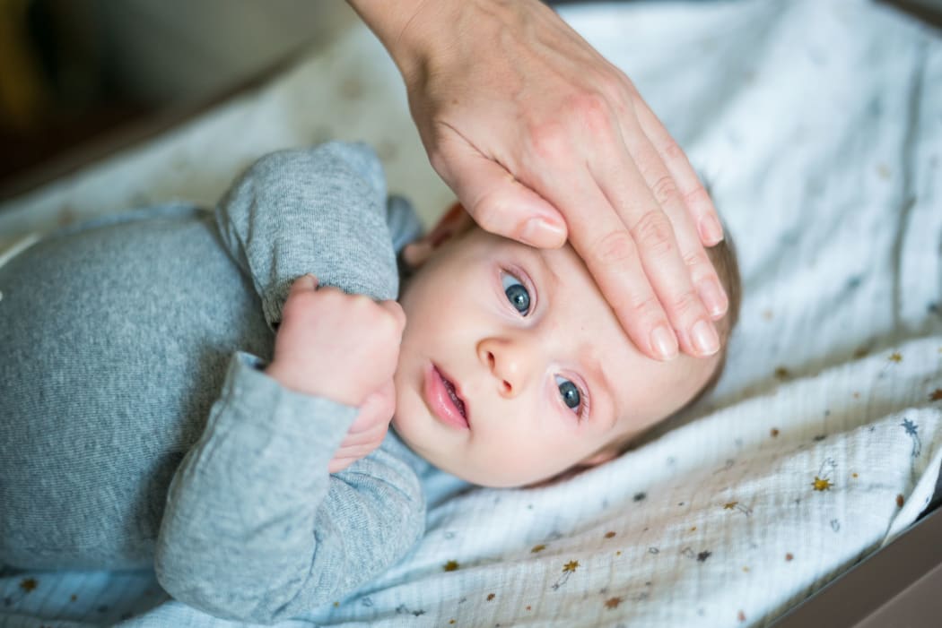 Checking the temperature of 3 month old baby boy.