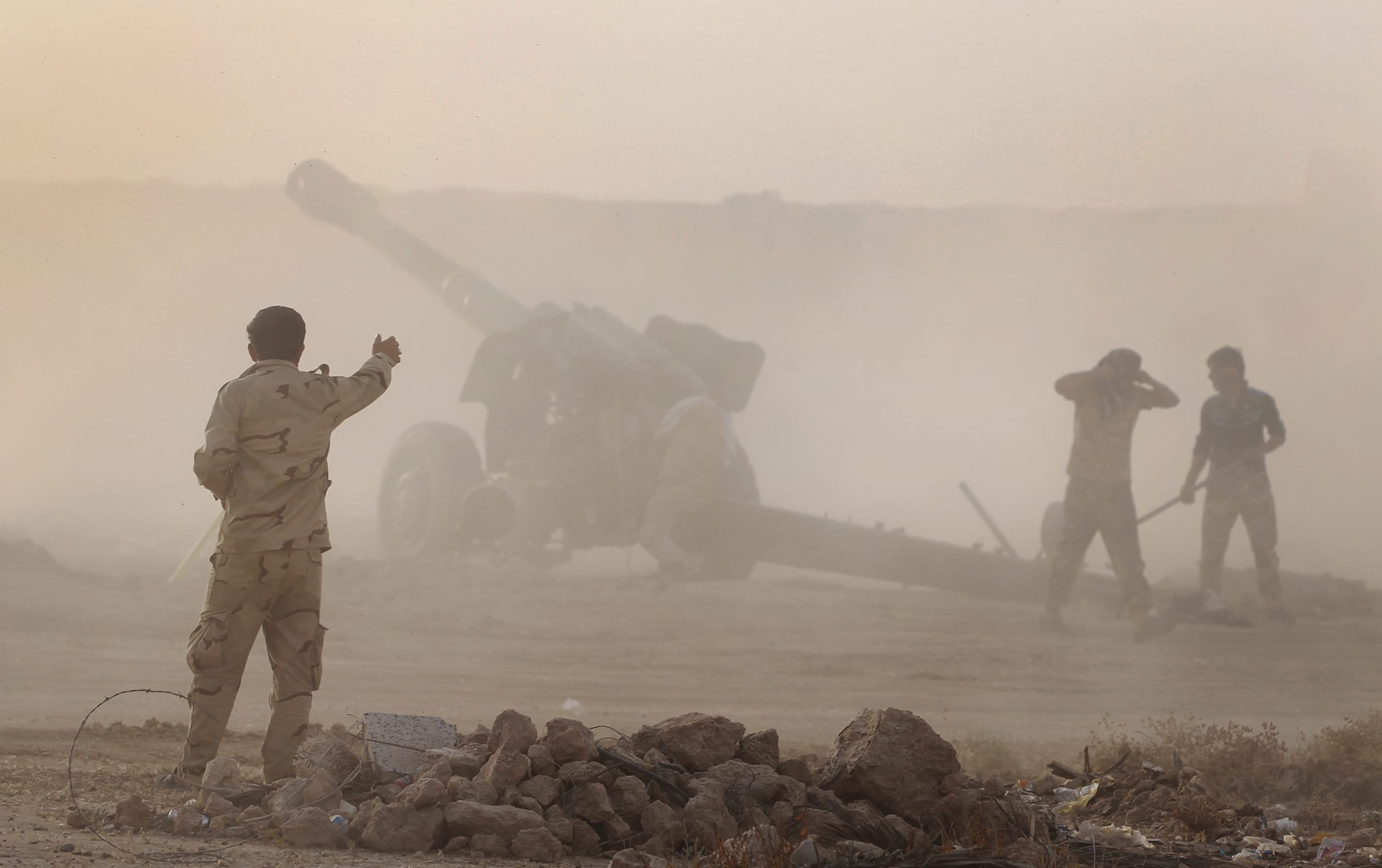 Iraqi Shiite fighters from a Popular Mobilisation unit use mobile artillery near the city of Fallujah.