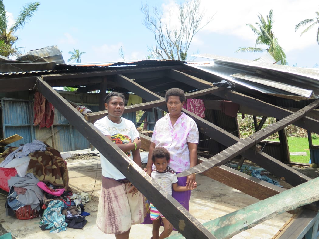 Usenia Nemai and daughters Rusila, 18, and Marie Grace, 5, stand at what used to be the lounge of their two-bedroom home in Driti village.