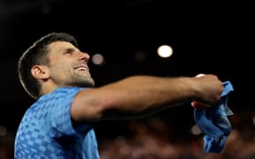Serbia's Novak Djokovic throws a cap towards a fan as he celebrates victory against Australia's Alex De Minaur after their men's singles match on day eight of the Australian Open tennis tournament in Melbourne.