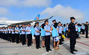 The 77 suspects, shown here in pictures released by China's Xinhua news agency, were paraded when they landed in Changchun, in China's northeast.