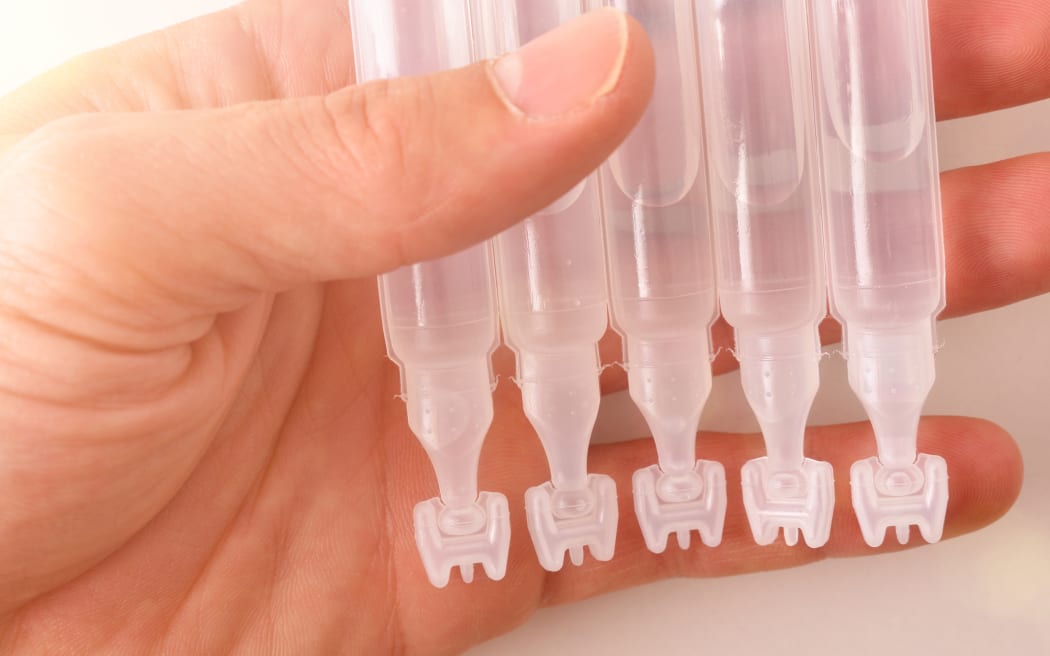 Hand with capsules of eye drops