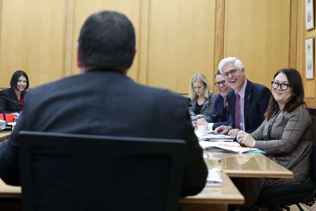 They may be opponents but funny is funny. Members of the Social Services committee enjoy a joke with Minister of Finance Grant Robertson