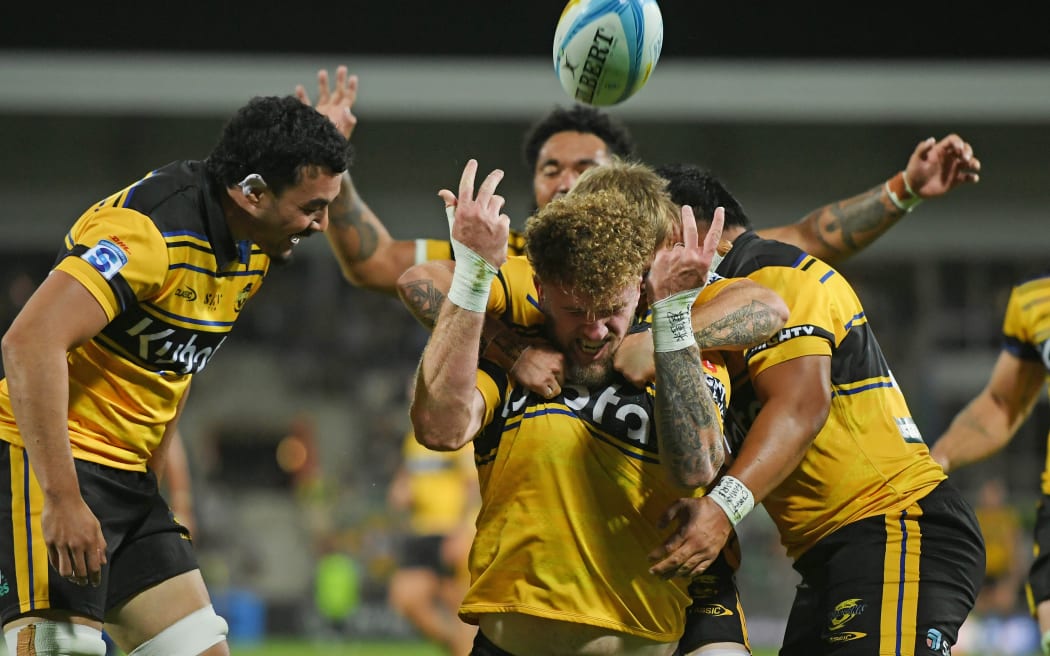 Hurricanes player Warner Dearns celebrates after he scores a try.