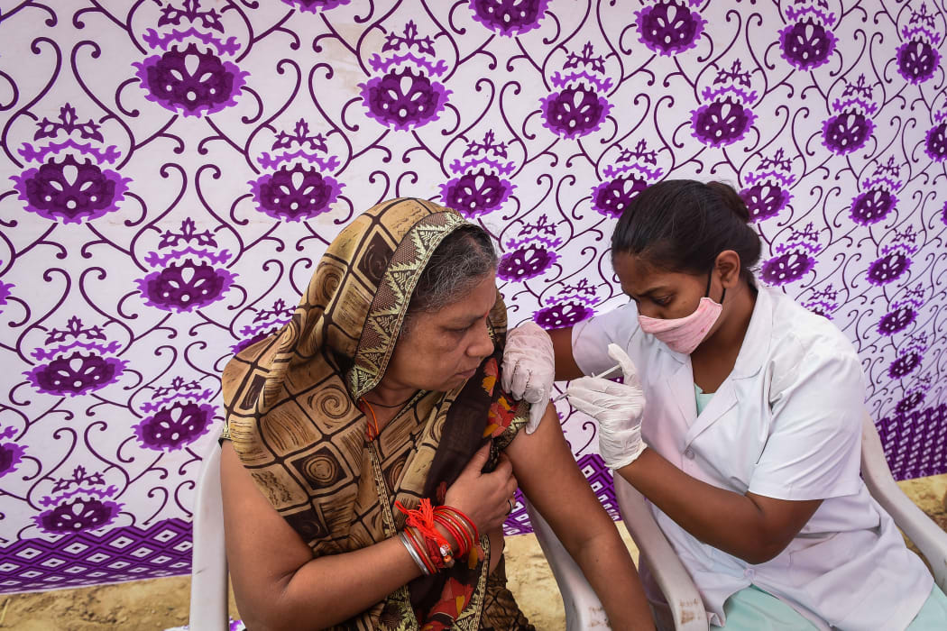 A health worker inoculates a woman with the jab of Covishield Covid-19 coronavirus vaccine at a temporary vaccination camp in Ahmedabad, India.