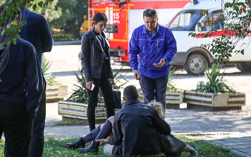 A rescuer carries an injured victim at the college in the city of Kerch.
