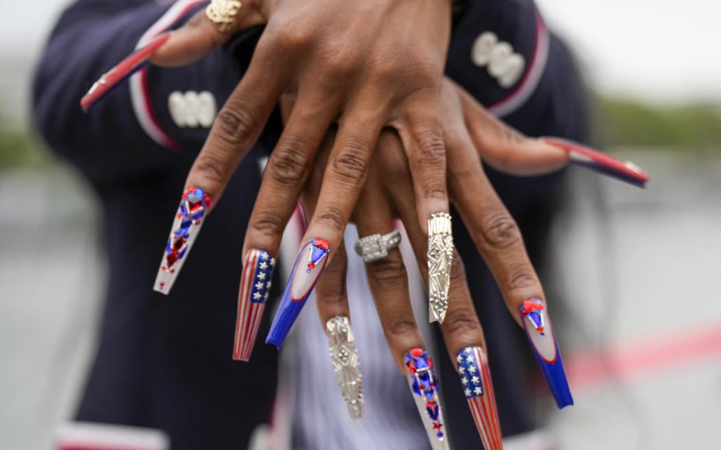 Sha'Carri Richardson, of the United States, shows off her nails while traveling along the Seine River, during the opening ceremony of the 2024 Summer Olympics in Paris on July 26, 2024.