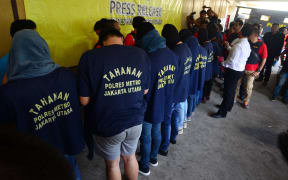 Men arrested in a recent raid stand in line during a news  conference at a police station in Jakarta on 22 May.