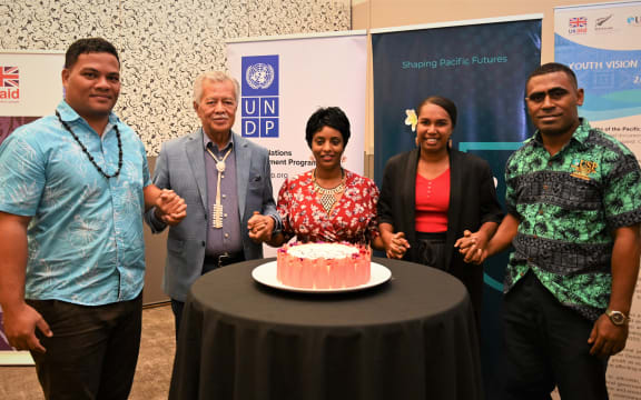 Simon Kofe, Henry Puna and Yemesrach Workie (left to right) join hands with two others for the launch of the Pacific Youth Advisory Board on Governance.