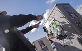 Loafers Lodge resident Chris, last name unknown, lays flowers near the building for his friends he lost in the fire on 16 May, 2023.