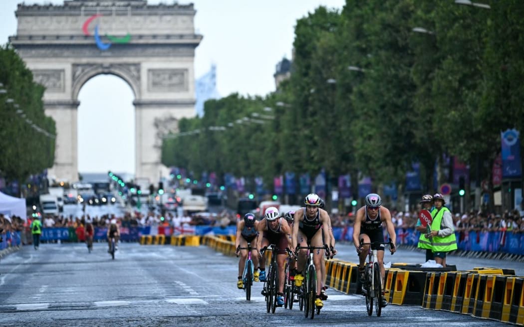 Athletes compete in the cycling race during the women's individual triathlon at the Paris 2024 Olympic Games in central Paris on July 31, 2024. (Photo by Ben STANSALL / AFP)