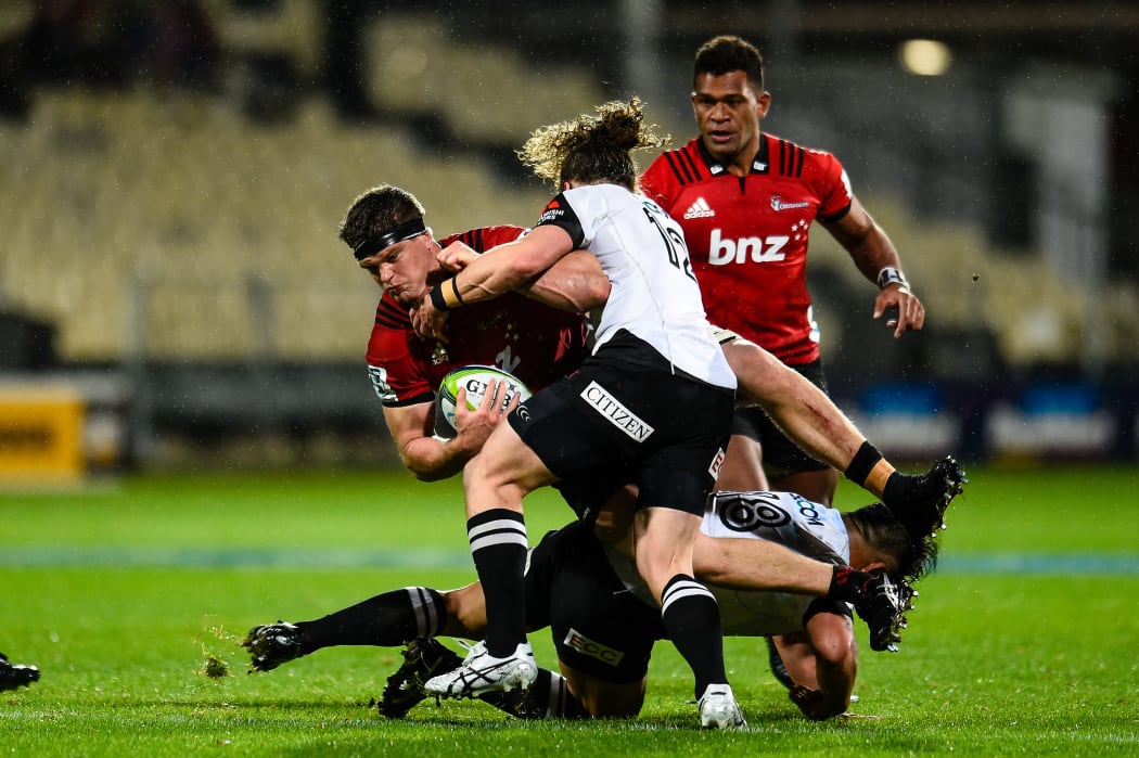 Scott Barrett of the Crusaders is tackled by Michael Little and Takuma Asahara of the Sunwolves during the Super Rugby match, Crusaders V Sunwolves,