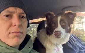 Matt and his missing dog Sadie sitting in the front of his car.