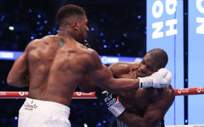 Britain's Anthony Joshua (L) and Britain's Daniel Dubois fight during their heavyweight boxing match for the IBF world title at Wembley Stadium in London on September 21, 2024.  (Photo by Adrian Dennis / AFP)