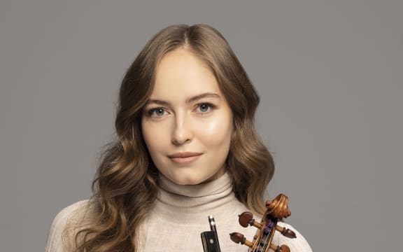 Geneva Lewis holds violin and bow