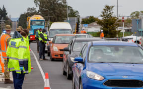 Police and military personnel check vehicles leaving the city at a COVID-19 check point setup at the southern boundary in Auckland on August 14, 2020.