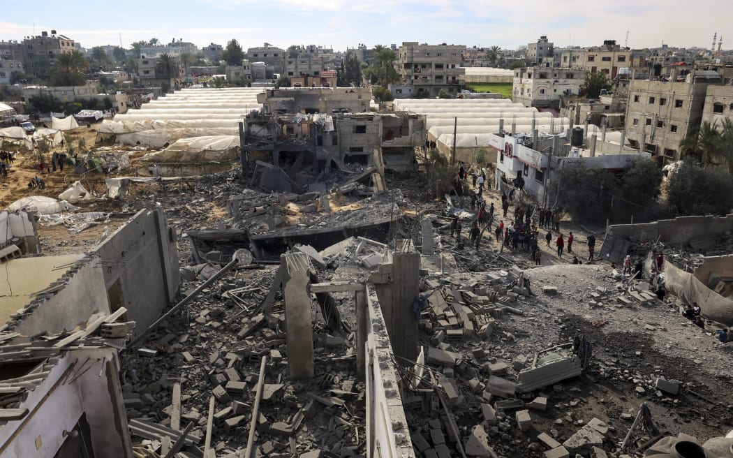 Palestinians inspect the damage amid the rubble of a building where two hostages were reportedly held before being rescued during an operation by Israeli security forces in Rafah, on the southern Gaza Strip on February 12, 2024.