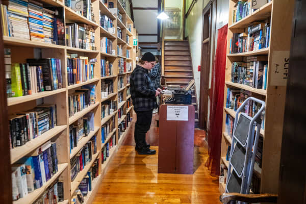 A person stands looking through the books at Hard to find Books store at Eden Terrace.