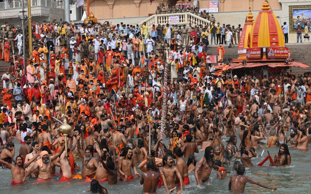 Naga Sadhus (Hindu holy men) take a holy dip in the waters of the Ganges River on the day of Shahi Snan (royal bath) during the ongoing religious Kumbh Mela festival, in Haridwar, north India, on April 12, 2021.