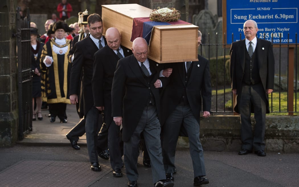 The oak coffin with the remains of King Richard III is carried out of St Nicholas Church in Leicester.