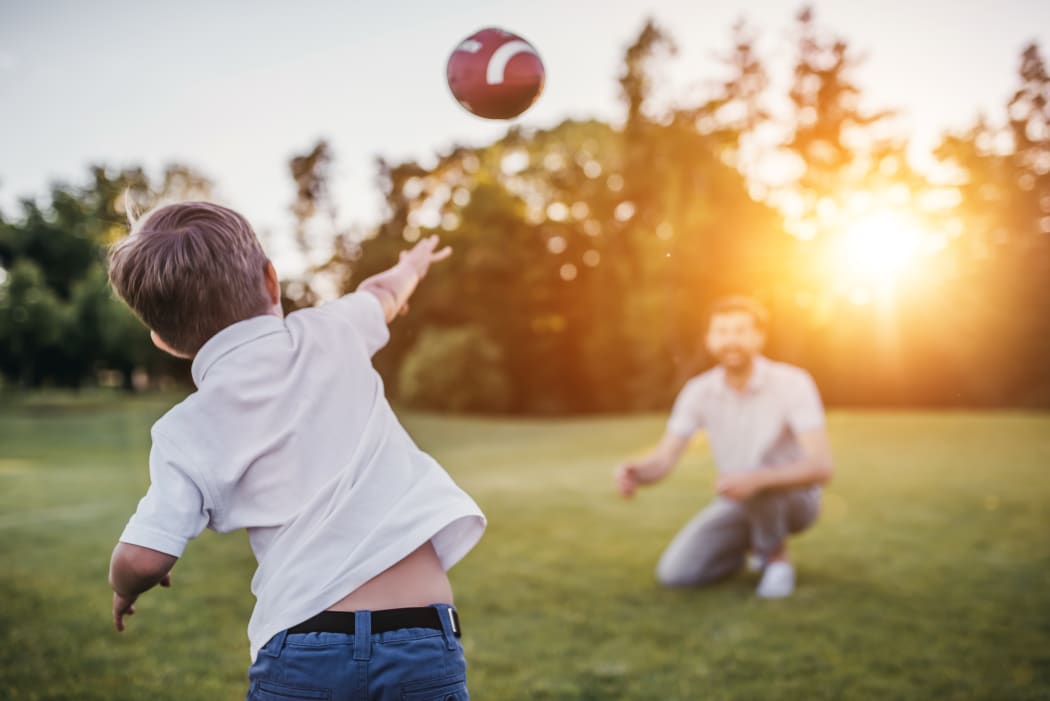 Father playing his son outside.