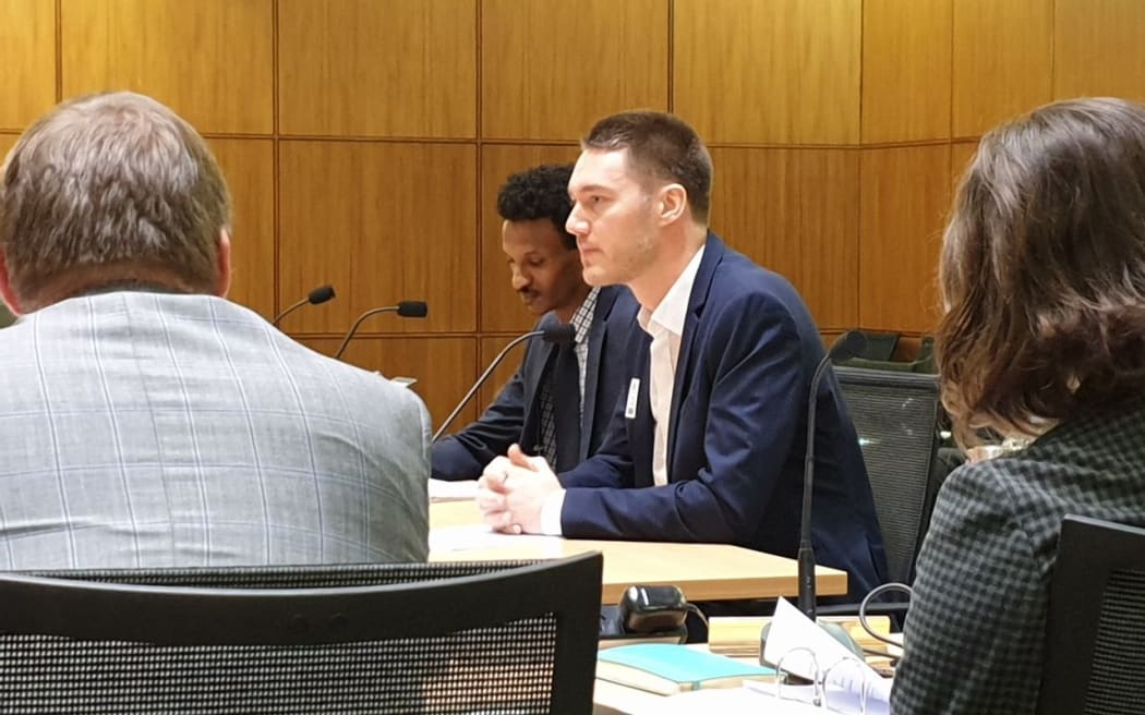 Former refugee and Muslim community advocate Guled Mire, and World Vision advocacy spokesperson Carsten Bockemuehl speak at the select committee today.