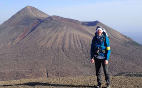 Christ Conway is wearing tramping gear and standing in front of a Japanese volcano.