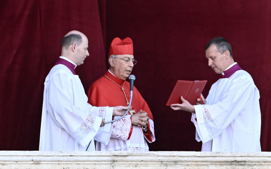 French cardinal Protodeacon Dominique Mamberti (C) announces the name of the new pope from the main central loggia balcony of the St Peter's Basilica, after the cardinals successfully ended the conclave voting, in The Vatican, on May 8, 2025. (Photo by Filippo MONTEFORTE / AFP)