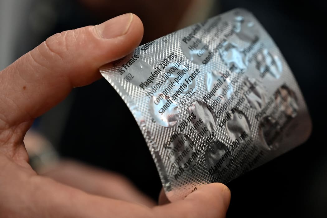 Medical staff shows on February 26, 2020 at the IHU Mediterranee Infection Institute in Marseille, a packet of Plaqueril, tablets containing hydroxychloroquine, drug that has shown signs of effectiveness against coronavirus.