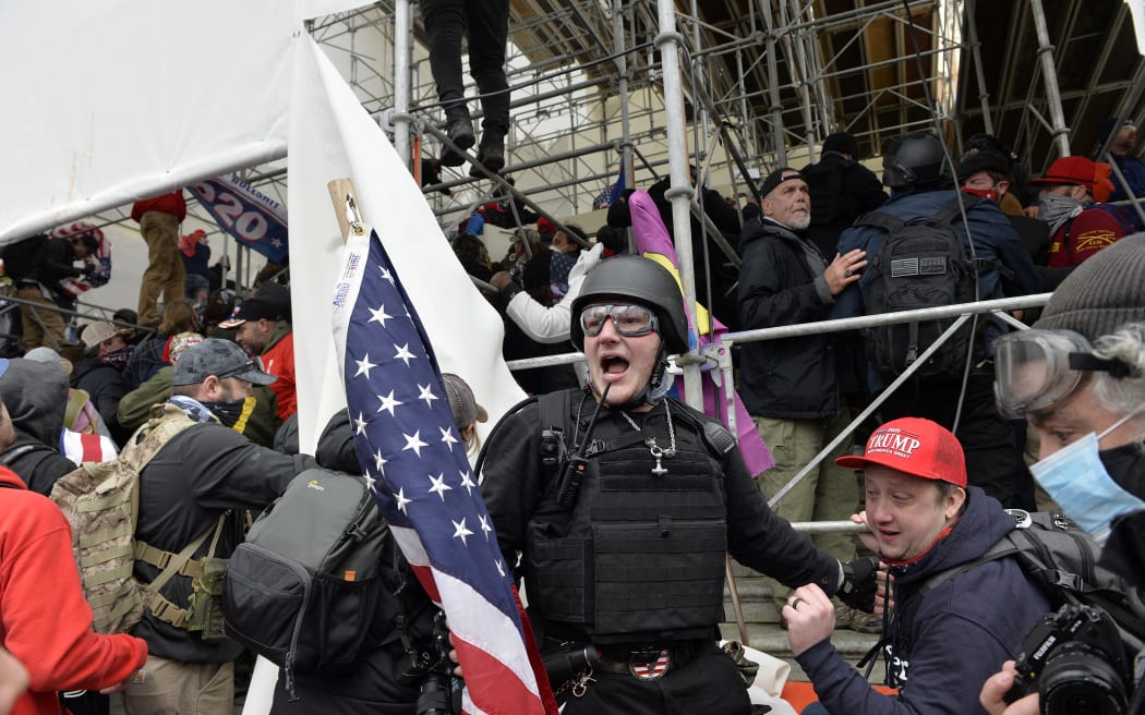 A man calls on people to raid the building as Trump supporters clash with police and security forces as they try to storm the US Capitol building in Washington, DC on January 6, 2021.