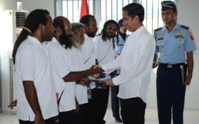 Indonesia's President Joko Widodo shakes hands with freed Papuan political prisoner Kimanus Wenda (2nd L) while four others Jefrai Murib (L) Apotnalogolik Lokobal (3rd L) Numbungga Telenggen (4th L) and Linus Hiluka (3rd R) during a ceremony at Abepura prison in Papua Province.