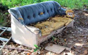 Old broken sofa thrown in the trash,