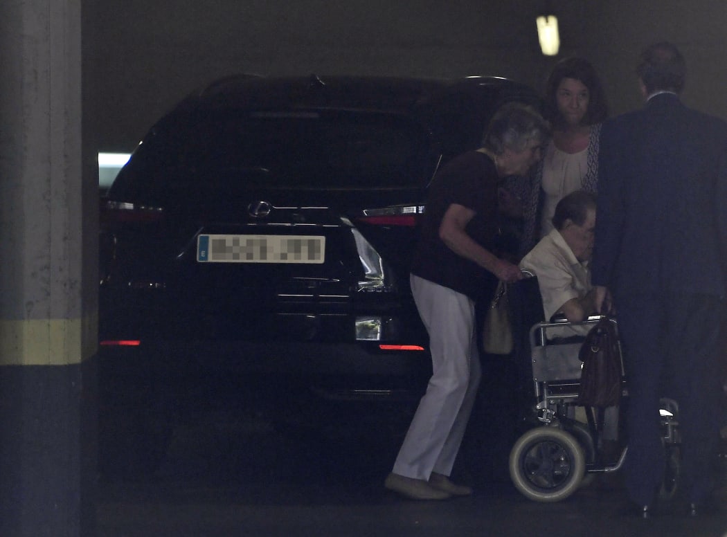 A man, believed to be Spanish former doctor Eduardo Vela (centre), 85, is pushed on a wheelchair as he arrives at a provincial court in Madrid.