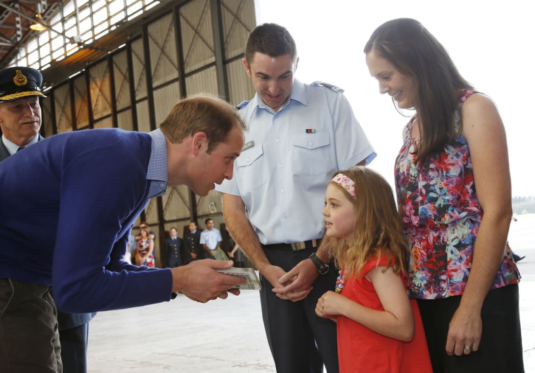 Maia Hunt offers a book to William, watched by her parents at Whenuapai air base.