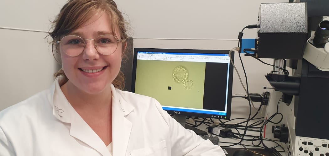 Fertility researcher Melanie Olds with what she describes as a lovely mouse embryo magnified on the screen behind her.