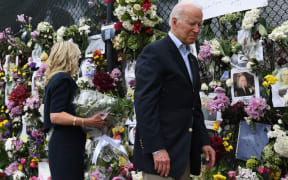 US President Joe Biden and US First Lady Jill Biden visit a photo wall, the 'Surfside Wall of Hope & Memorial', near the partially collapsed 12-story Champlain Towers South condo building in Surfside, Florida.