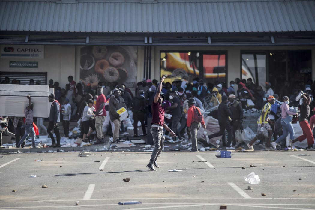A man gestures as rioters loot the Jabulani Mall in the Soweto district of Johannesburg on July 12, 2021.