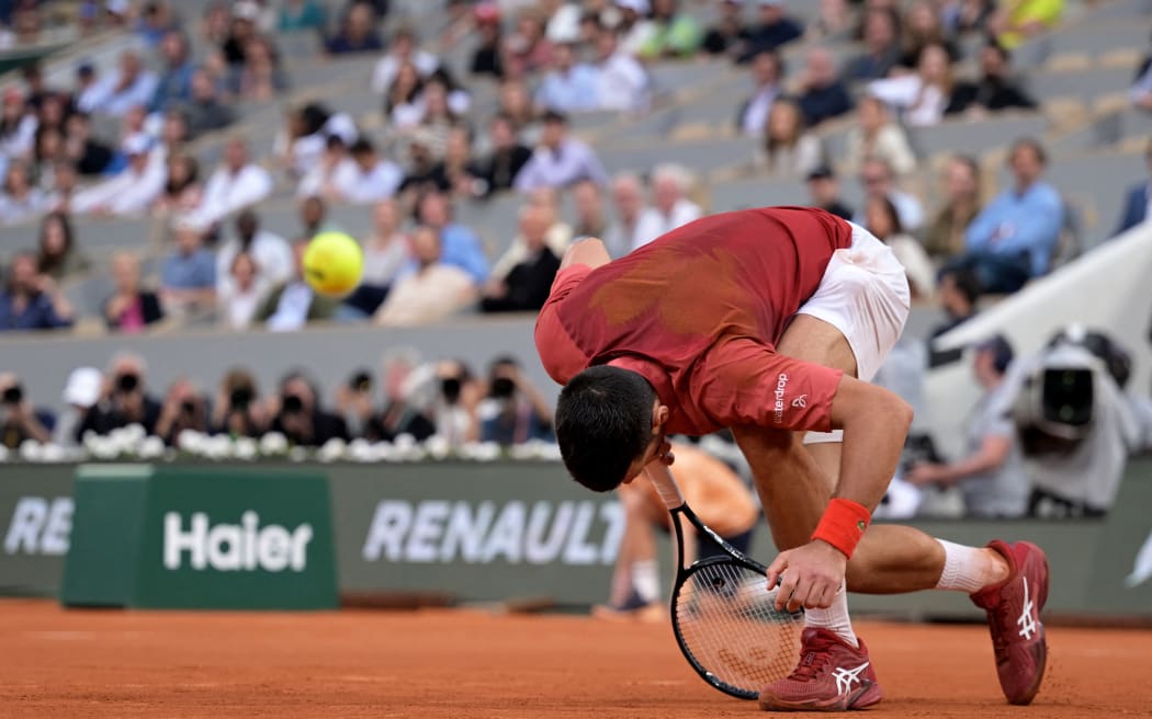 Serbia's Novak Djokovic falls on the court during his men's singles round of sixteen match against Argentina's Francisco Cerundolo on Court Philippe-Chatrier on day nine of the French Open tennis tournament at the Roland Garros Complex in Paris on June 3, 2024.