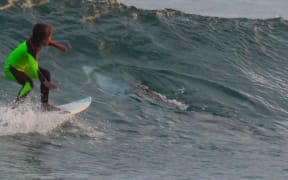 Eden Hasson, 10, was surfing north of Newcastle, Australia, when his father took this picture that showed a shark right next to the child.