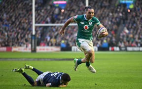 Ireland's wing James Lowe skips away from Scotland's fullback Blair Kinghorn on his way to scoring a try during the Six Nations international at Murrayfield Stadium in Edinburgh, 9 Feb, 2025.