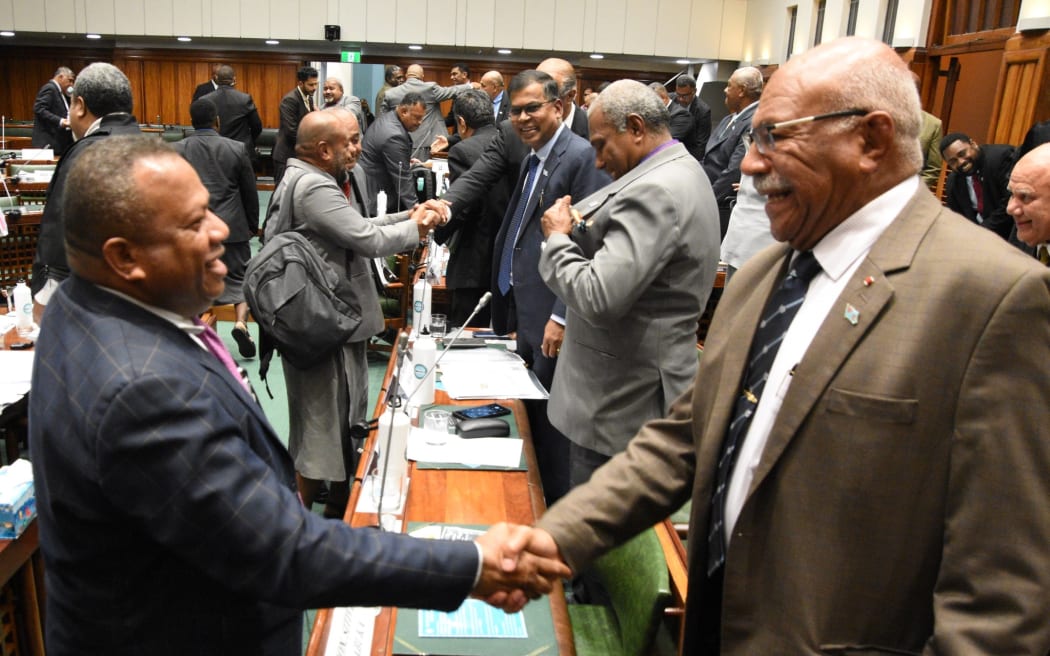 Fiji's Opposition Leader Inia Seruiratu (left) and Prime Minister Sitiveni Rabuka shake hands after the budget was passed, Thursday, July 13, 2023.